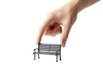 Hand holding miniature park bench against white backdrop, symbolizing small scale or control with clean and minimalist aesthetic.