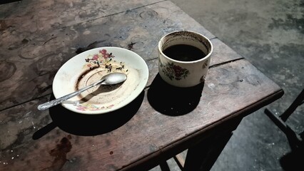 a cup of warm, sweet black coffee with lots of dregs 