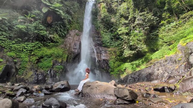 Woman at Gitgit waterfall in Bali , Singaraja, Indonesia