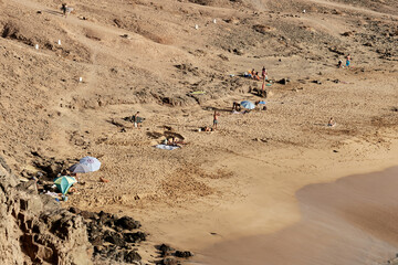 Obraz premium Golden sandy beach with sunbathers and surfers in El Cotillo, Fuerteventura, Canary Islands