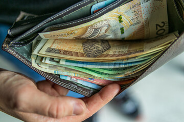 Thick wallet full of Polish zloty banknotes of different denominations.