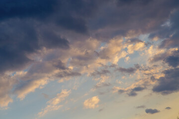 Large stormy dark cloud illuminated at the edges by the light of the setting sun close-up.