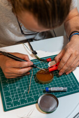 DIY electronics repair with soldering iron and tools on green mat