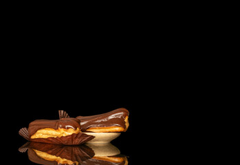 Chocolate sweet eclair, macro, isolated on black  background.