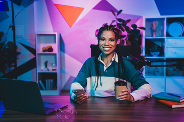 Podcaster professional woman broadcasting a podcast in a neon-lit workspace with vibrant colors and modern equipment
