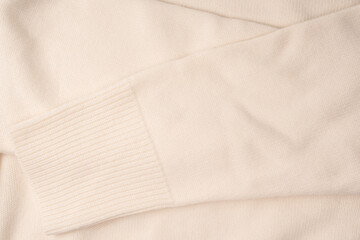 Soft milky color merino wool sweater texture as a background.