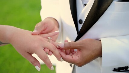The groom puts on the wedding ring on the bride finger, at the wedding ceremony. 