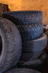texture of several old tires stacked and abandoned in a dark and dirty room