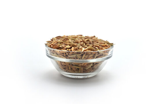 FRESH RICE GRAIN ON GLASS BOWL FRONT VIEW ON ISOLATED WHITE BACKGROUND WITH SELECTIVE FOCUS.