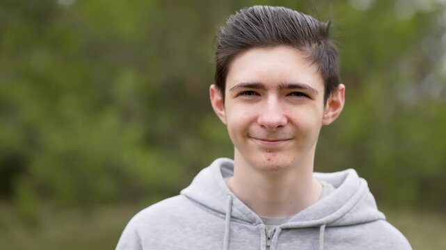 Portrait happy boy with teenage acne smiling outdoors during puberty. Joyful adolescent with pimples smiling outdoor, experiencing puberty. Cheerful young boy with acne grinning in fresh air going
