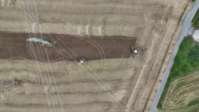 Aerial drone footage of a combine harvester cutting a golden wheat field, showcasing modern agriculture, grain harvest, rural landscape, and seasonal farming productivity.