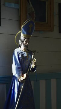 Wooden crucifix of Jesus on cross inside church with flowers on altar
