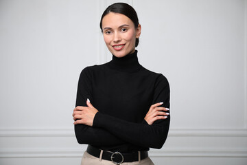 Portrait of beautiful woman near white wall