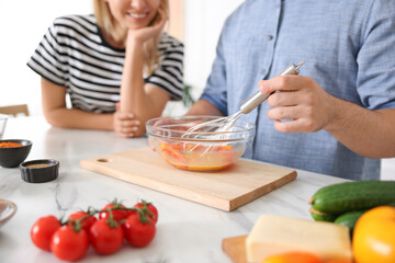 Couple cooking together at table indoors, closeup