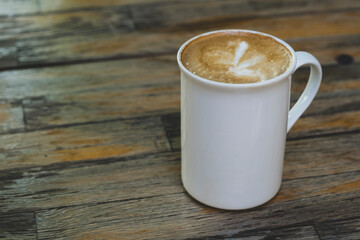 Latte in White Cup on Wooden Table. Cozy Latte Coffee Cup on Wooden Background. Morning Latte in Ceramic Mug on Wood Table.