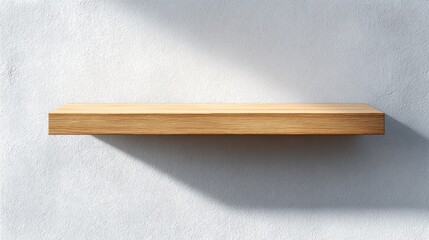 Empty wooden floating shelf on a textured white wall with sunlight and shadow.