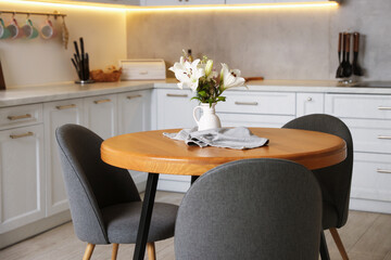 Dining table, chairs and floral decor in kitchen. Interior design