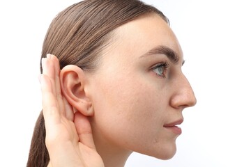 Naklejka premium Sound. Woman showing hand to ear gesture on white background, closeup