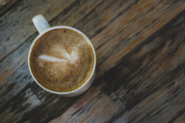 Latte in White Cup on Wooden Table. Cozy Latte Coffee Cup on Wooden Background. Morning Latte in Ceramic Mug on Wood Table.