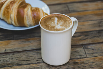 Latte Coffee and Croissant on Wooden Table. Cup of Latte and Croissant Morning Snack. Delicious Latte with Fresh Croissant on Table. Fresh Croissant with Cup of Latte.