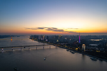 Wuhan river scene shows Yangtze river bridge and city lights at sunset.