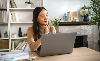 woman is sitting at  desk with  laptop in front of her