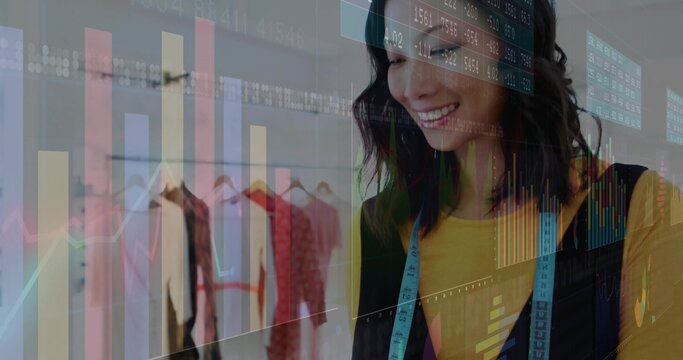 Smiling mid-adult Asian fashion designer wearing tape measure in studio, chart overlay, copy space - Powered by Adobe