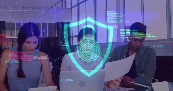 Three professionals focusing on devices in modern office meeting area, with digital shield hologram - Powered by Adobe