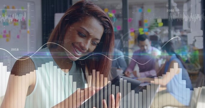 Smiling auburn-haired teammate tapping tablet in office, with laptops sticky notes data overlays - Powered by Adobe