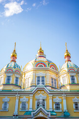 Obraz premium Bright close-up view of the golden domes and colorful details of Zenkov Cathedral in Almaty, Kazakhstan. This iconic wooden Orthodox church, painted in vivid patterns with a yellow facade