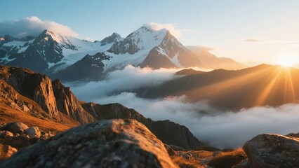 Sunrise over snow-capped mountains with clouds filling the valleys