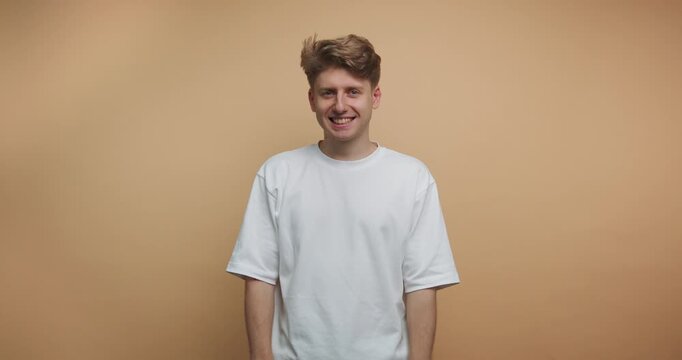 Smiling man expresses joy and positivity in a light setting during an enjoyable moment captured on camera