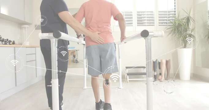 Patient stepping onto bar set activating sensor graphics as therapist steadying posture for rehab