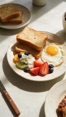 A plate of breakfast food featuring toast, a fried egg, yogurt, and fresh fruit including strawberries, blueberries, kiwi, and orange slices.