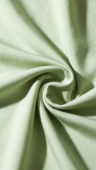 Close-up of soft green fabric with swirling folds and smooth texture