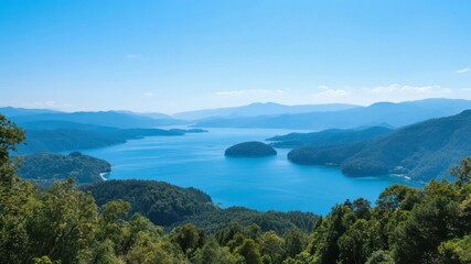 Aerial view of a serene blue lake surrounded by lush green mountains under a clear sky