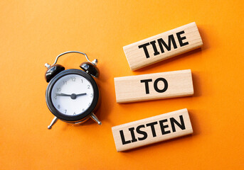Time to listen symbol. Concept words Time to listen on wooden blocks. Beautiful orange background with alarm clock. Business and Time to listen concept. Copy space.
