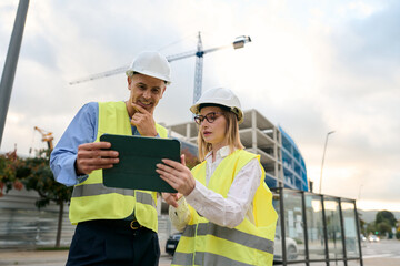 Engineers reviewing construction plans on digital tablet