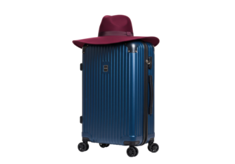 Isolated suitcase with hat on top, perfect for business travel, vacation or getaway trip