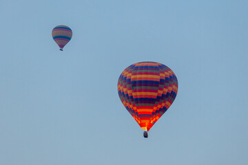 Three hot air balloons against a blue sky. Beautiful view of colourful hot air balloons from below. Cappadocia