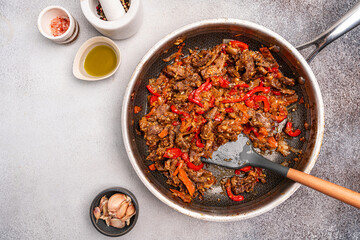 Stir-fried Beef Skirt Steak and Paprika with Oyster Sauce in a pan on gray background. Top view with copy space
