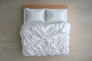 Unmade bed with crumpled white duvet and pillows on a light wooden floor, top view.
