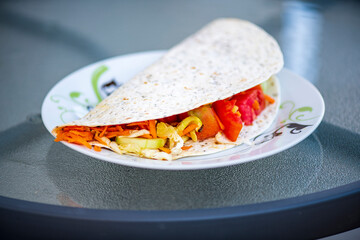 Fresh tortilla wrap filled with sliced salami, juicy tomato, and crisp lettuce cous—perfect for a quick snack or healthy lunch. Bright colors and natural light highlight the savory ingredients, making