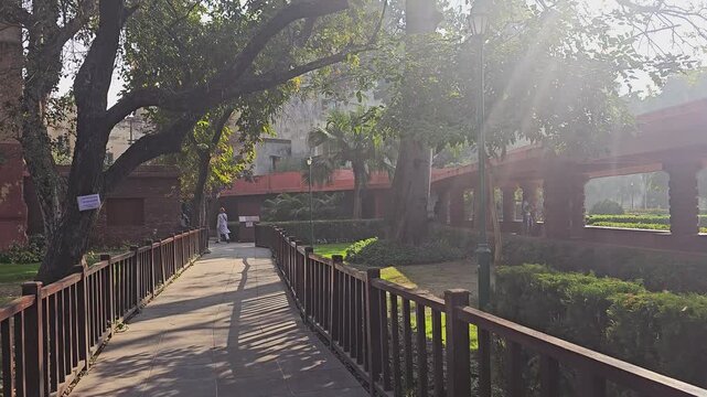 Pathway inside Jallianwala Bagh garden, Amritsar, surrounded by greenery and memorial structures. Visitors walk through the site that commemorates a tragic chapter of Indian history.