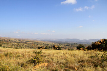 Fototapeta premium Landscape photo of stunning views from the Magaliesberg mountains, with interesting rock formations. trees, and water pools. 