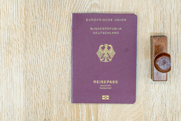 Passport of the German Republic on a wooden table and a stamp. Business and holiday travel concept