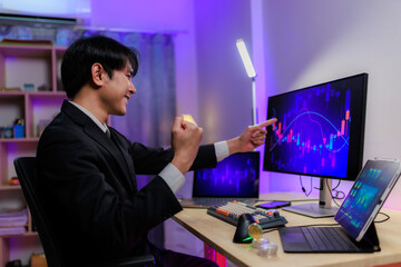 Happy investor raising fist while watching bullish charts.