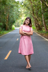Portrait of a beautiful young woman walking on a road through a lush forest. Portrait of Asian.