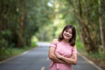 Portrait of a beautiful young woman walking on a road through a lush forest. Portrait of Asian.