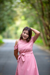 Portrait of a beautiful young woman walking on a road through a lush forest. Portrait of Asian.